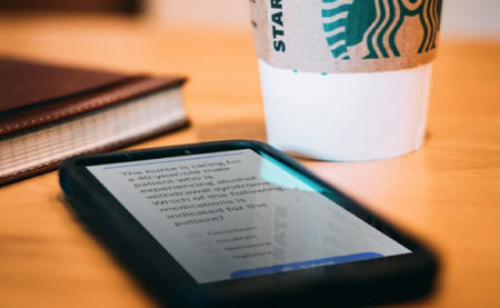 iPhone and coffee next to book