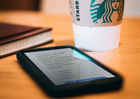 iPhone and coffee next to book